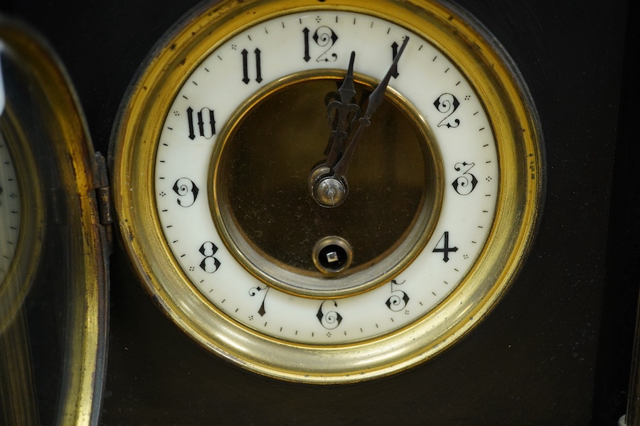 A black slate clock and a pair of garnitures, clock 30cm high. Condition - garnitures worn